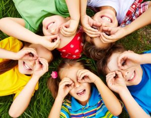 cinq jeunes enfants allongés sur l'herbe
