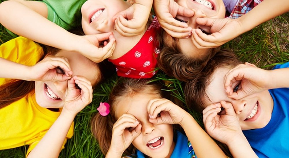 cinq jeunes enfants allongés sur l'herbe